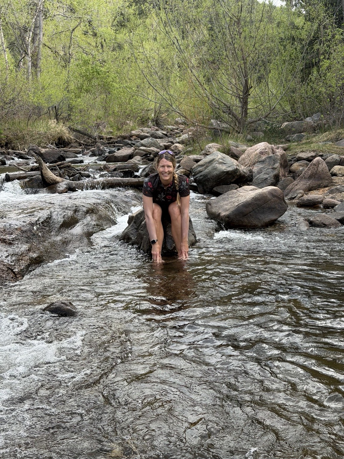 Linda Hjelmåker outdoors beside a mountain stream